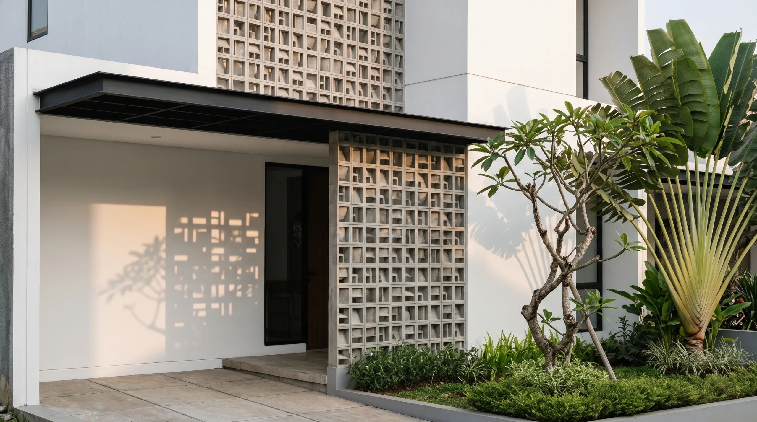 Fasad rumah sederhana dan elegan dengan aplikasi dinding roster beton geometris untuk sirkulasi udara dan privasi